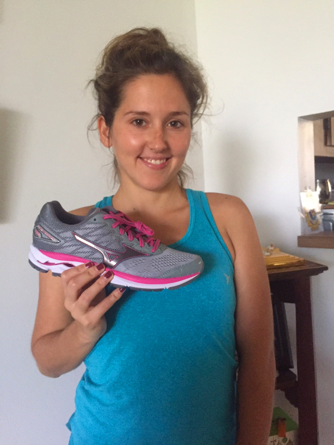 Happy runner girl with new Mizuno shoes in hand